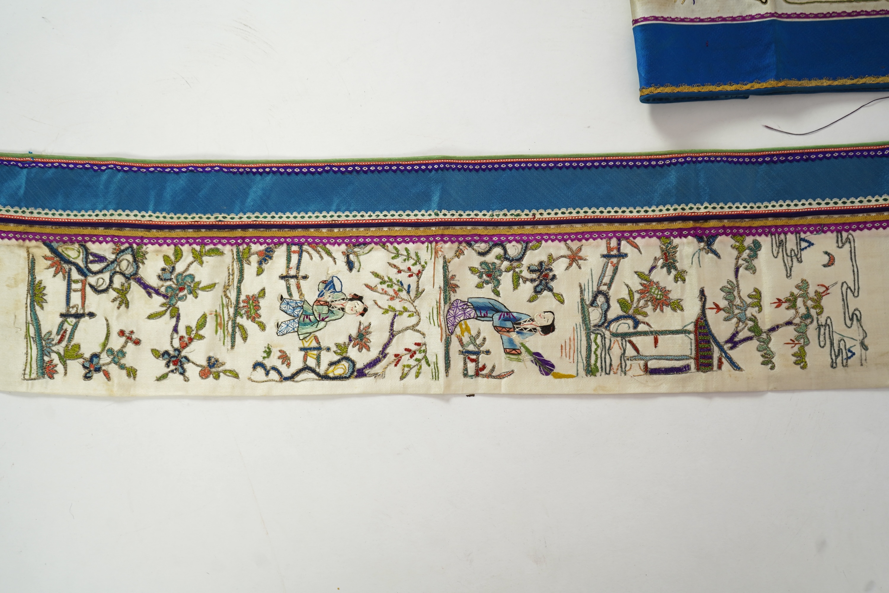 A Chinese embroidered silk panel of uncut robe borders, eleven similar sleeve panels and two other items, late Qing dynasty